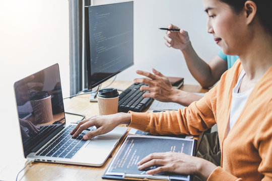 Two professional programmer cooperating and working on web site project in a software developing on desktop computer at company, codes and typing data code, Programming with HTML, PHP and javascript