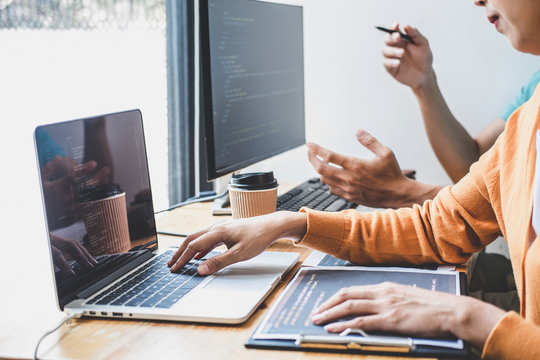 Programmers cooperating at Developing programming and website working in a software develop company office, writing codes and typing data code, Programming with HTML, PHP and javascript