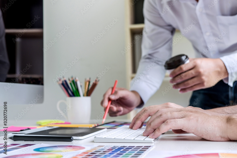 Poster Two colleagues creative graphic designer working on color selection and drawing on graphics tablet at workplace
