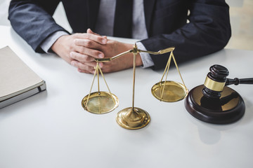 Male lawyer or judge working with contract papers, Law books and wooden gavel on table in...
