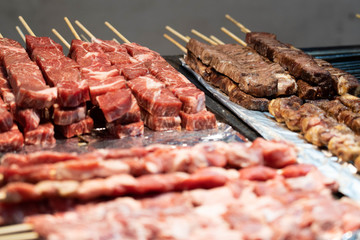 Korean barbecue beef skewers raw and cooked on a tray. Korean street foods being displayed in Myeongdong, South Korea.