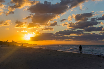 Fototapeta na wymiar Silhouettes of people at sunset on the Atlantic ocean