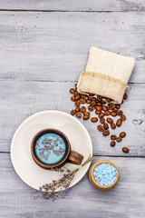 Trendy colored latte. Lavender and powdered aromatic sugar, coffee beans. Wooden boards background