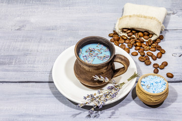 Trendy colored latte. Lavender and powdered aromatic sugar, coffee beans. Wooden boards background