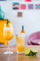 Close-up of two orange fresh fruit cocktail drinks with pineapple in a tall glass.