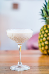 Close-up of banana milk cocktail served in a champagne glass.