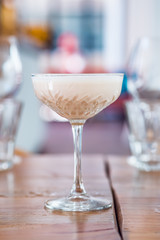 Close-up of banana milk cocktail served in a champagne glass.