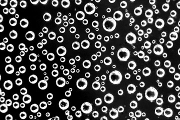 Air balls in water on a black background