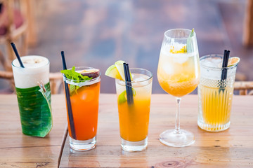 Selection of alcoholic and milkskake cocktails on a wooden table.