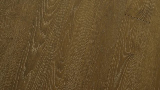 Close-up of wooden floors made of solid planks of dark oak in brown tones, parquet floors, solid wood floors. Circular motion of the camera.