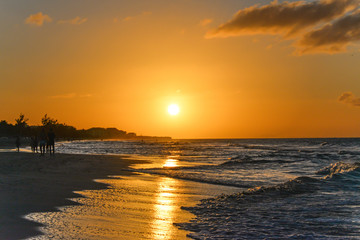 Silhouettes of people at sunset on the beach of Atlantic ocean, Cuba