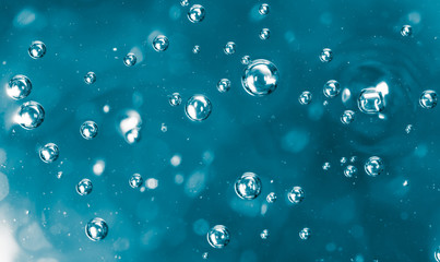 Bubbles of air on the smooth surface of blue water as an abstract background