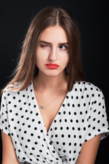 Studio portrait of a young girl with long hair and red lips.