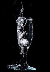 Water with splashes in a glass on a black background