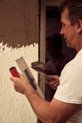 Construction worker plaster a wall.	