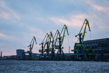Fototapeta na wymiar Port view of multiple big shipping cargo cranes.