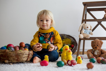 Fototapeta na wymiar Toddler child, blonde boy playing with Easter eggs. Children plays with eggs and chicks