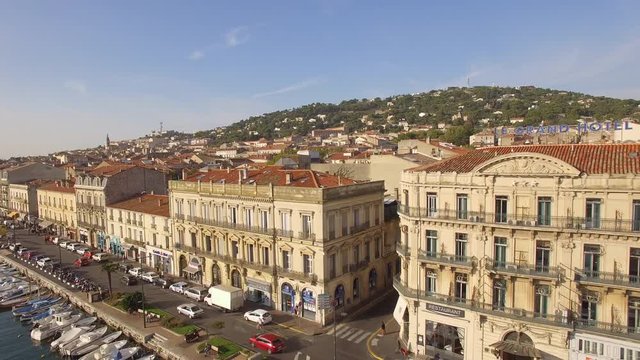 Sunrise drone shot on S&egrave;te. Nice traveling with cars driving along the channel with little fishing barques.Nice city colors in backround with the &laquo;&nbsp;Grand Hotel&nbsp;&raquo; and the Mont Saint Clair. The Venice o