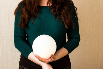 A red-haired girl in a green jacket with a white ball in her hands