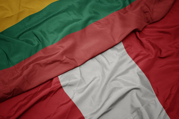 waving colorful flag of peru and national flag of lithuania.