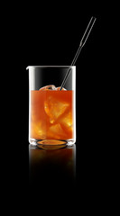 Whisky cocktail in mixing glass with reflection.