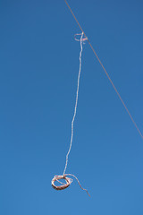 String is hanging on the cable. Minimalist image with clear blue sky as large copy space area. Very shallow depth of field.