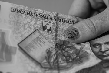 Woman hand giving money like bribe or tips isolated . LEI currency banknotes close up. Reward for...