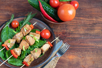 Chicken breast skewers with bell pepper. The meat is marinated in soy sauce with honey and mustard. Decorated with sprigs of rosemary. In the background are soy and vegetables for the salad.