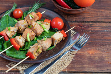 Chicken breast skewers with bell pepper. The meat is marinated in soy sauce with honey and mustard. Decorated with sprigs of rosemary. In the background are soy and vegetables for the salad.