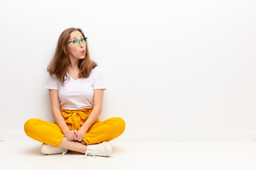 yound blonde woman with a goofy, crazy, surprised expression, puffing cheeks, feeling stuffed, fat...