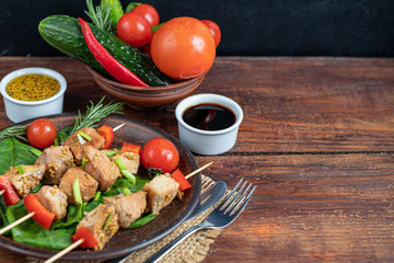 Fototapeta na wymiar Chicken breast skewers with bell pepper. The meat is marinated in soy sauce with honey and mustard. Decorated with sprigs of rosemary. In the background are soy and vegetables for the salad.