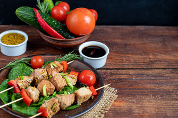 Chicken breast skewers with bell pepper. The meat is marinated in soy sauce with honey and mustard. Decorated with sprigs of rosemary. In the background are soy and vegetables for the salad.