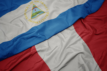 waving colorful flag of peru and national flag of nicaragua.