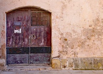 Weathered and worn brown garage door in Sliema, Malta