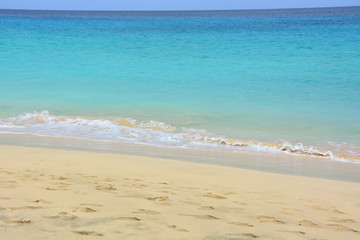 Fototapeta na wymiar Natural background, a beautiful sandy beach and turquoise, blue calm ocean, sea on a sunny day on Sal Island in Cape Verde, Cab