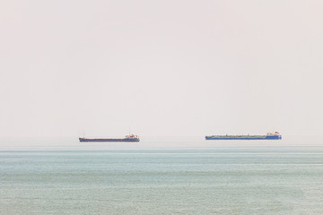 Two freight ship in sea on heat hazy horizon