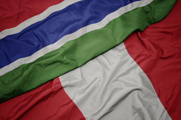 waving colorful flag of peru and national flag of gambia.