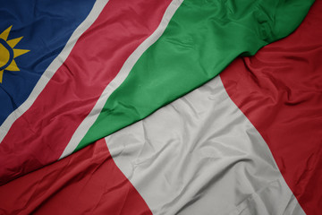 waving colorful flag of peru and national flag of namibia.