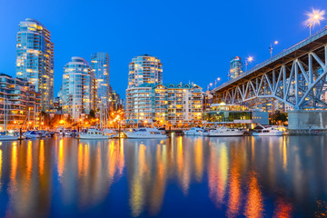Fototapeta na wymiar Vancouver BC skyscrapers and Granville Bridge reflection along False Creek at blue hour