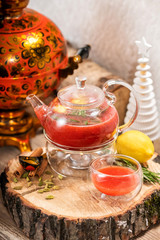 Hot fruit red berry tea with steam in the teapot with mint, berries, lemon slices on wooden background. Food and drink. New year holidays, christmas xmas dinner concept