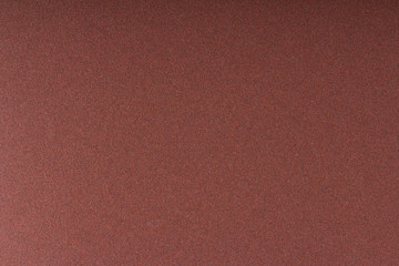 A texture of a coarse grit sandpaper