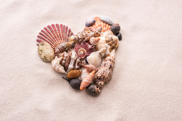 A heart made of small shells on the beach sand is love and St. Valentine's Day