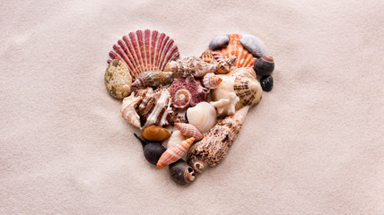 A heart made of small shells on the beach sand is love and St. Valentine's Day
