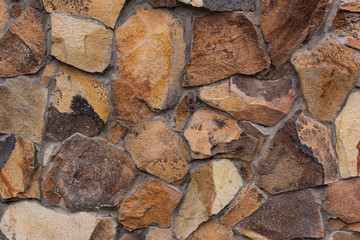 Fragment of natural massive stone wall. Abstract background for design.