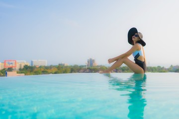 Portrait beautiful young asian woman happy smile relax around outdoor swimming pool in hotel resort