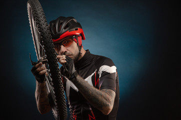 Fototapeta premium guy-cyclist in a Bicycle helmet with a Bicycle wheel