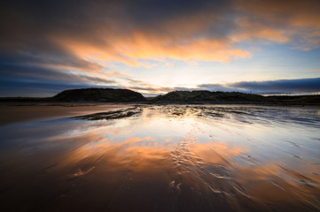 Reflected Sunset on wet sand at Cocklawburn Beach, a rural beach within Northumberland Coast Area...
