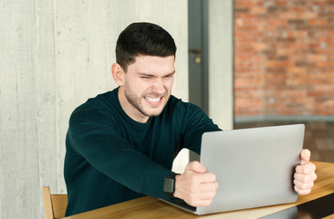 Mad Office Guy Breaking Laptop Sitting At Workplace Indoor