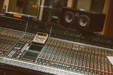 Professional audio mixing console with faders and adjusting knobs
