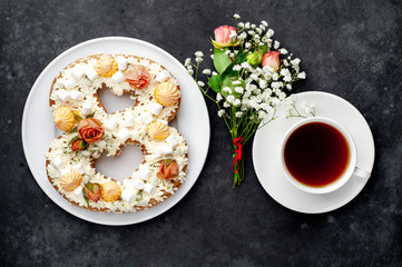 tea and cake in the form of 8 is decorated with flowers, cream cheese, marshmallows, Bizet on a stone background. romantic delicious breakfast on International Women's Day March 8